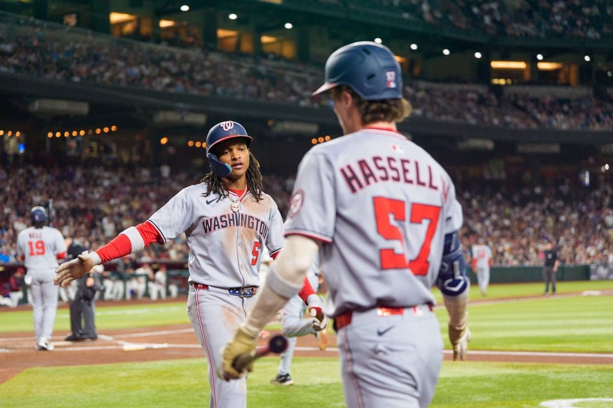 May 31, 2025; Phoenix, Arizona, USA;  Washington Nationals infielder CJ Abrams (5) and outfielder Robert Hassell III (57) celebrate after Abrams scores in the first inning against the Arizona Diamondbacks at Chase Field. Mandatory Credit: Allan Henry-Imagn Images