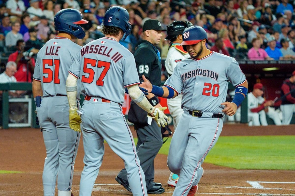 May 31, 2025; Phoenix, Arizona, USA;  Washington Nationals catcher Keibert Ruiz (20) celebrates with outfielder Daylen Lile (51) and outfielder Robert Hassell III (57) after scoring against the Arizona Diamondbacks in the first inning at Chase Field. Mandatory Credit: Allan Henry-Imagn Images