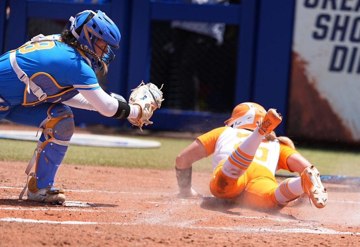 Tennessee's McKenna Gibson (24) slides into home for a score as UCLA's Alexis Ramirez (28) tries to place the tag in the first inning of the Women's College World Series softball game between the UCLA Bruins and the Tennessee Volunteers at Devon Park in Oklahoma City, Sunday, June, 1, 2025.