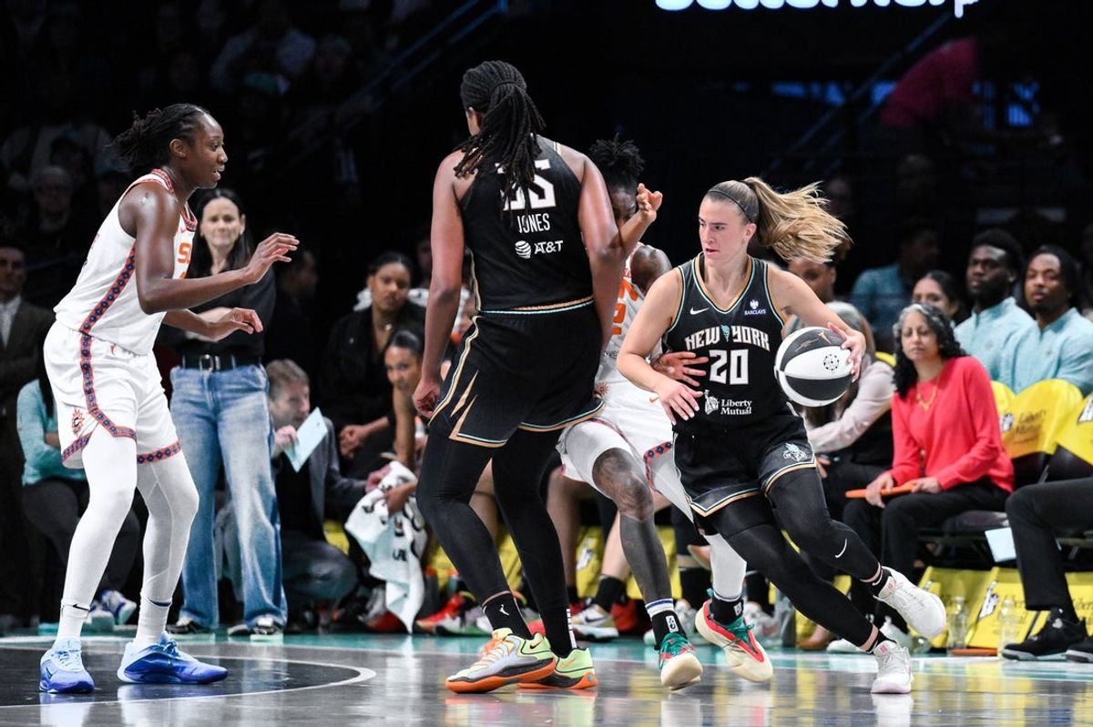 Jun 1, 2025; Brooklyn, New York, USA; New York Liberty guard Sabrina Ionescu (20) drives past Connecticut Sun guard Saniya Rivers (22) during the first half at Barclays Center. Mandatory Credit: John Jones-Imagn Images