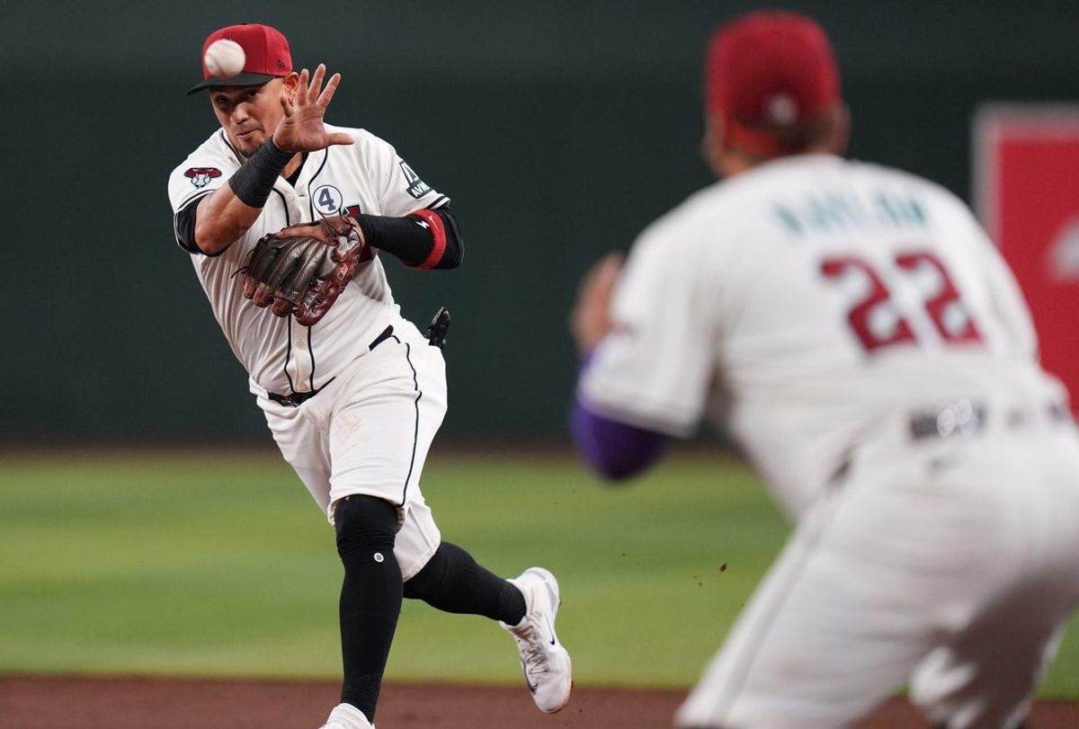 Arizona Diamondbacks infielder Ildemaro Vargas (6) throws to Josh Naylor (22) for the out at first base against the Washington Nationals at Chase Field in Phoenix on June 1, 2025.