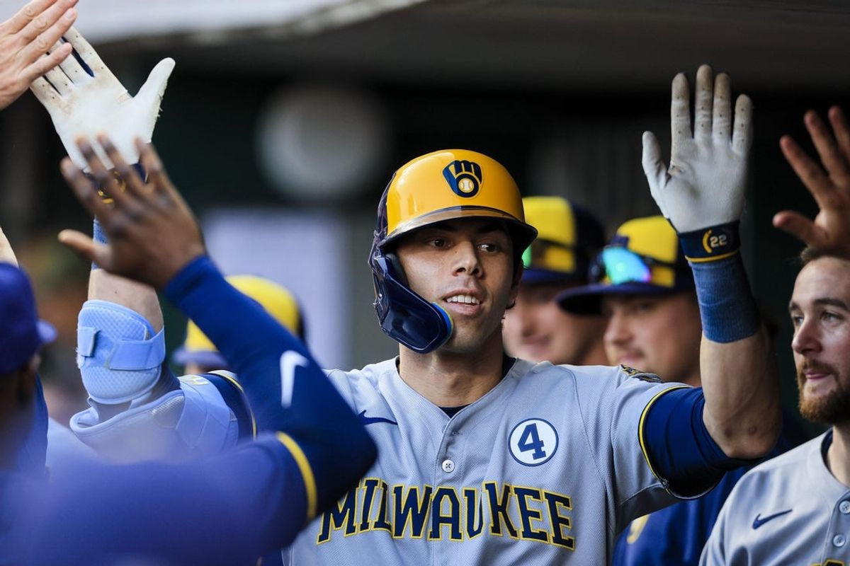 Jun 2, 2025; Cincinnati, Ohio, USA; Milwaukee Brewers designated hitter Christian Yelich (22) high fives teammates after hitting a solo home run in the third inning against the Cincinnati Reds at Great American Ball Park. Mandatory Credit: Katie Stratman-Imagn Images