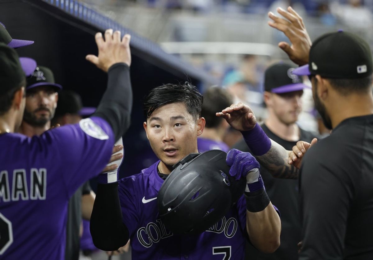 Jun 2, 2025; Miami, Florida, USA;  Colorado Rockies first baseman Keston Hiura (7) is greeted teammates in the dugout after scoring against the Miami Marlins during the ninth inning at loanDepot Park. Mandatory Credit: Rhona Wise-Imagn Images
