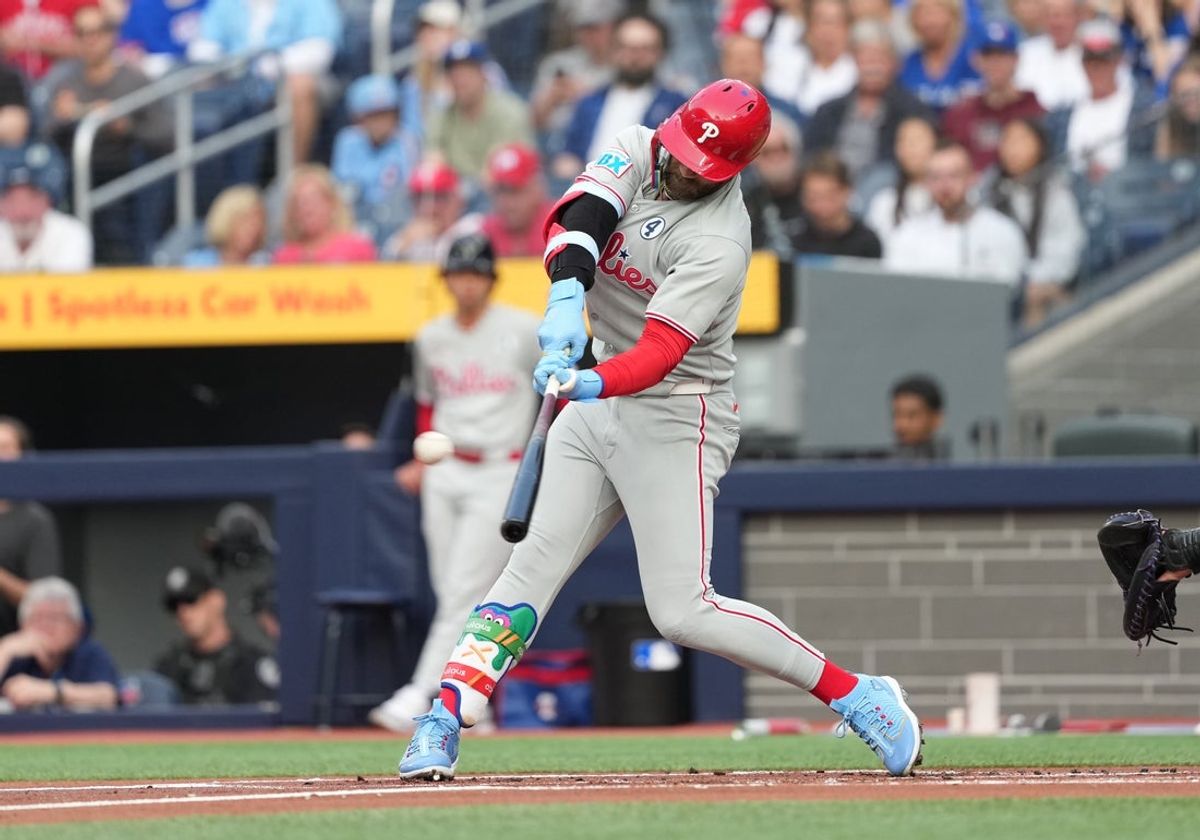 Jun 3, 2025; Toronto, Ontario, CAN; Philadelphia Phillies first baseman Bryce Harper (3) hits a home run against the Toronto Blue Jays during the first inning at Rogers Centre. Mandatory Credit: Nick Turchiaro-Imagn Images