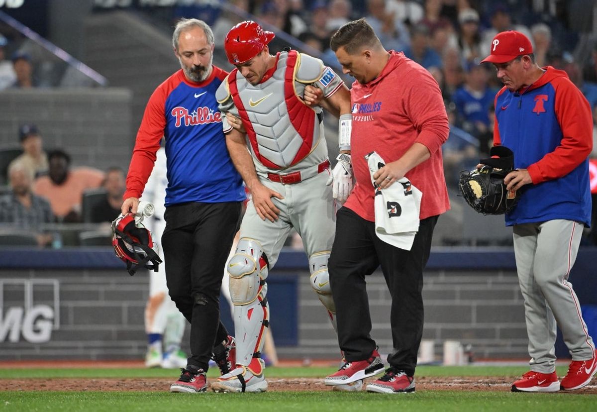 Jun 4, 2025; Toronto, Ontario, CAN;  Philadelphia Phillies catcher J.T. Realmuto (10) is helped off the field after being injured by a tip foul against the Toronto Blue Jays in the ninth inning at Rogers Centre. Mandatory Credit: Dan Hamilton-Imagn Images
