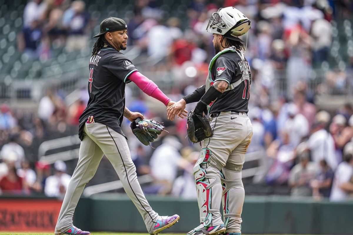 Jun 5, 2025; Cumberland, Georgia, USA; Arizona Diamondbacks second baseman Ketel Marte (4) reacts with catcher Jose Herrera (11) after the Diamondbacks defeated the Atlanta Braves at Truist Park. Mandatory Credit: Dale Zanine-Imagn Images