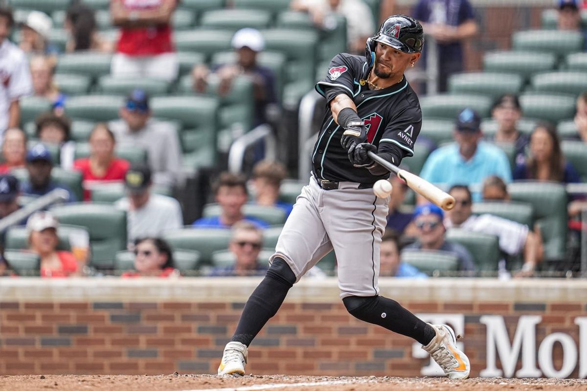Jun 5, 2025; Cumberland, Georgia, USA; Arizona Diamondbacks Ildemaro Vargas (6) gets a base hit to drive in a run against the Atlanta Braves during the ninth inning at Truist Park. Mandatory Credit: Dale Zanine-Imagn Images