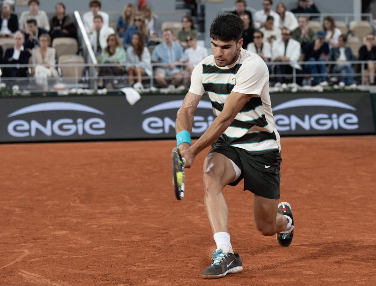 Jun 6, 2025; Paris, FR;  Carlos Alcaraz of Spain returns a shot during his match against Lorenzo Musetti of Italy match on day 13 at Roland Garros Stadium. Mandatory Credit: Susan Mullane-Imagn Images
