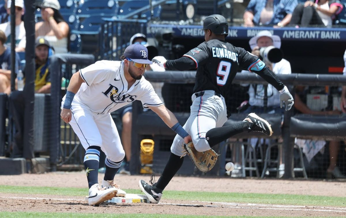 Jun 6, 2025; St. Petersburg, Florida, USA;  Miami Marlins infielder Xavier Edwards (9) gets called out on interference with Tampa Bay Rays first base Jonathan Aranda (62) during the third inning at George M. Steinbrenner Field. Mandatory Credit: Kim Klement Neitzel-Imagn Images