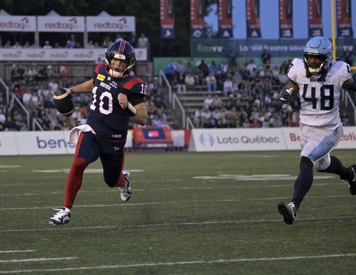Jun 6, 2025; Montreal, Quebec, Canada; Montreal Alouettes quarterback  Davis Alexander (10) rushes for a first down against Toronto Argonauts linebacker Wynton McMannis (48) during the first half at Percival-Molson stadium. Mandatory Credit: Eric Bolte-Imagn Images