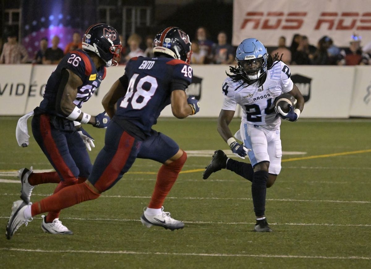 Jun 6, 2025; Montreal, Quebec, Canada; Toronto Argonauts running back Deonta McMahon (24) runs with the ball and Montreal Alouettes defensive back Kabion Ento (48) gives pursuit with teammate linebacker Tyrice Beverette (26) during the second half at Percival-Molson stadium. Mandatory Credit: Eric Bolte-Imagn Images