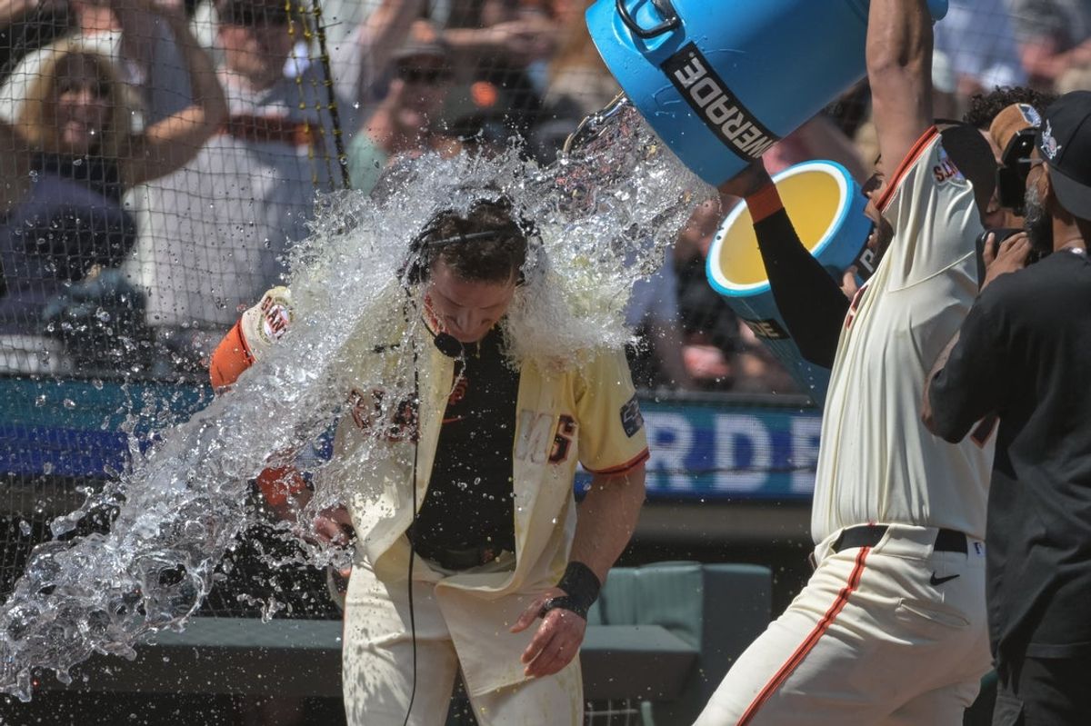 Jun 7, 2025; San Francisco, California, USA;  San Francisco Giants third baseman Matt Chapman (26) is doused with water after hitting a walk off home run against the Atlanta Braves during the ninth inning at Oracle Park. Mandatory Credit: Ed Szczepanski-Imagn Images