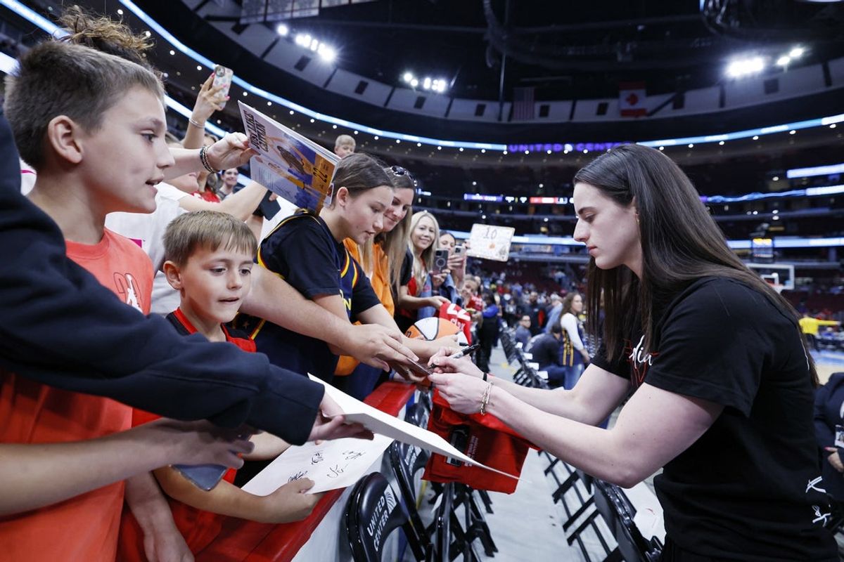Jun 7, 2025; Chicago, Illinois, USA; Indiana Fever guard Caitlin Clark (22) signs autographs before a WNBA game against the Chicago Sky at United Center. Mandatory Credit: Kamil Krzaczynski-Imagn Images