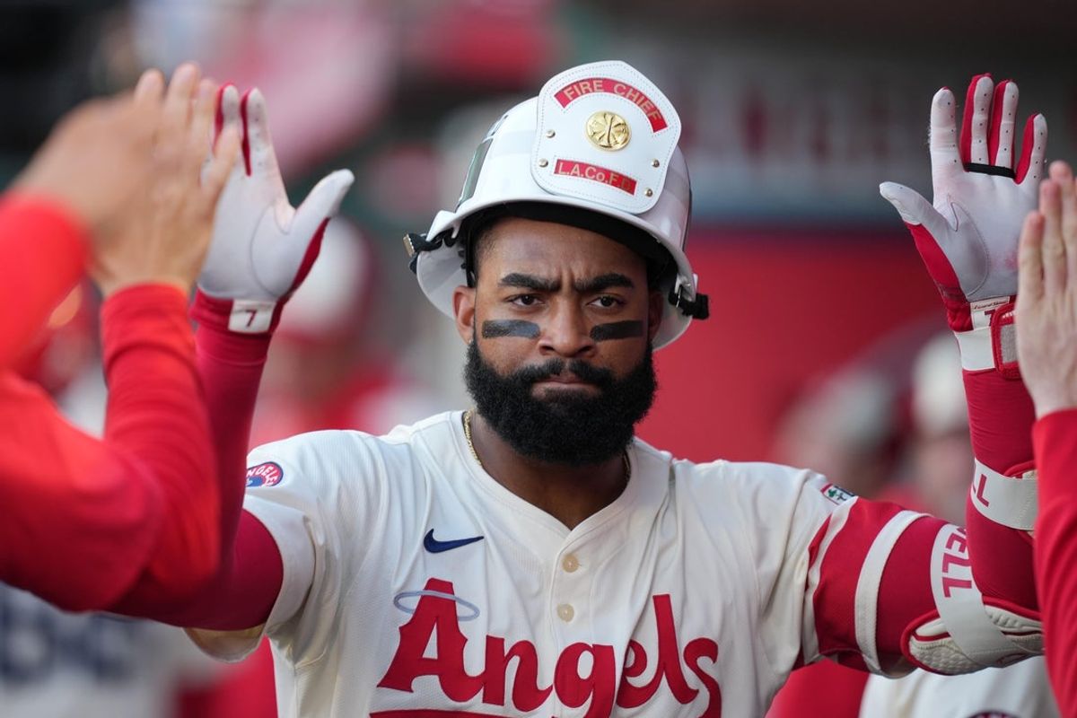 Jun 7, 2025; Anaheim, California, USA; Los Angeles Angels center fielder Jo Adell (7) wears a firefighter helmet after hitting a home run in the second inning against the Seattle Mariners at Angel Stadium. Mandatory Credit: Kirby Lee-Imagn Images