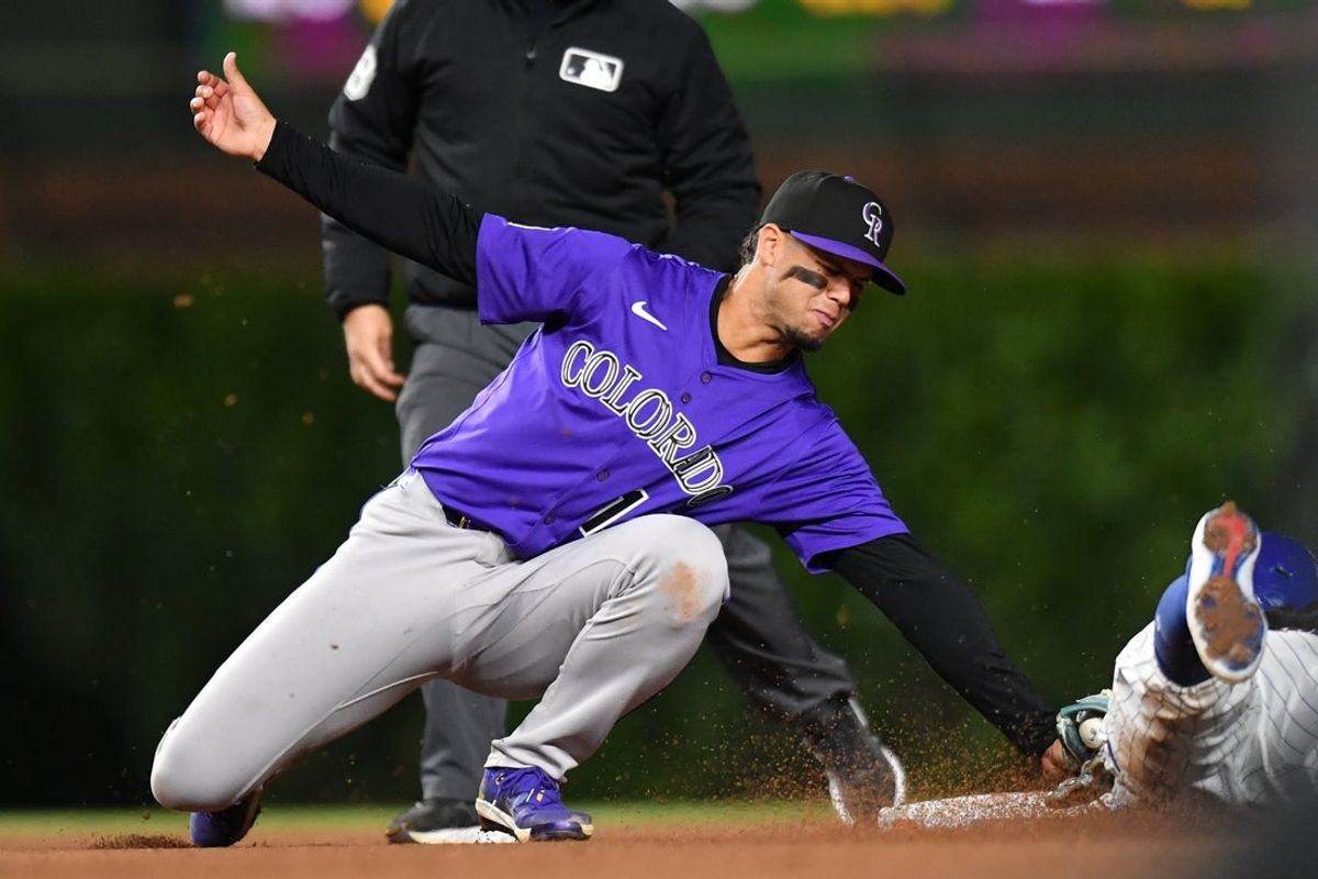 May 27, 2025; Chicago, Illinois, USA; Colorado Rockies shortstop Ezequiel Tovar (14) tags out Chicago Cubs shortstop Dansby Swanson (7) while attempting to steal during the eighth inning at Wrigley Field. Mandatory Credit: Patrick Gorski-Imagn Images