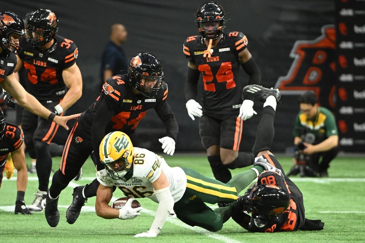 Jun 7, 2025; Vancouver, British Columbia, Canada;  BC Lions wide reciever Exechiel Tieide (80) tackles Edmonton Elks wide receiver Arkell Smith (86) during the second half at BC Place Stadium. Mandatory Credit: Anne-Marie Sorvin-Imagn Images