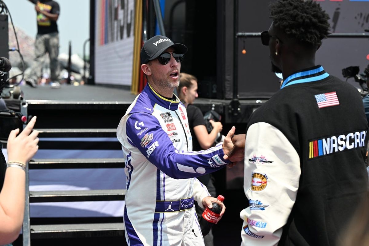 Jun 8, 2025; Brooklyn, Michigan, USA; NASCAR Cup Series driver Denny Hamlin (11) greets Detroit Lions safety Kerby Joseph during driver introductions before the start of the FireKeepers Casino 400 at Michigan International Speedway. Mandatory Credit: Lon Horwedel-Imagn Images