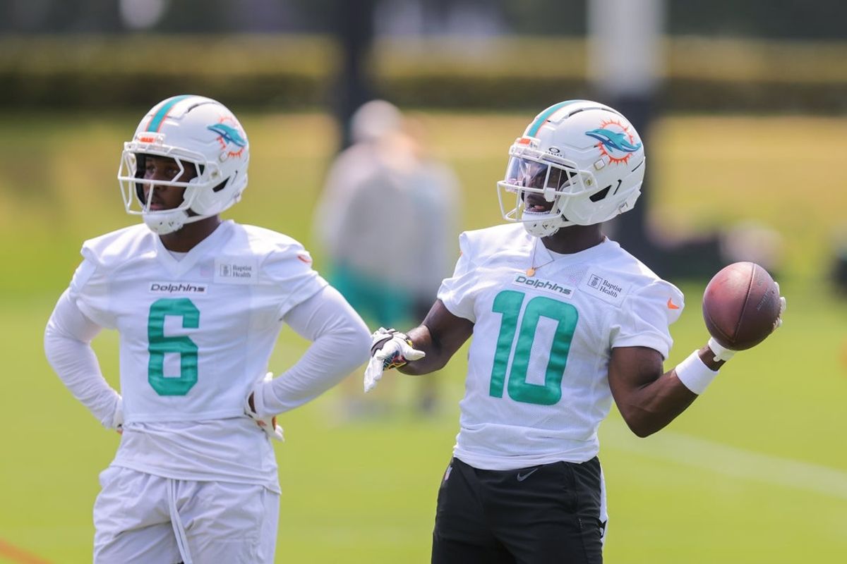 Jun 10, 2025; Miami, FL, USA; Miami Dolphins wide receiver Tyreek Hill (10) tosses a football as wide receiver Malik Washington (6) looks on during mandatory minicamp at Hard Rock Stadium. Mandatory Credit: Sam Navarro-Imagn Images