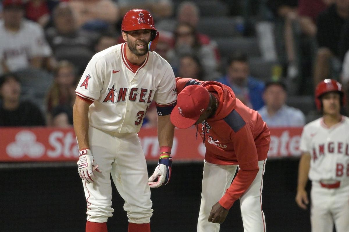 Jun 9, 2025; Anaheim, California, USA;  Los Angeles Angels manager Ron Washington (37) checks on center fielder Chris Taylor (33) after he was hit by a pitch left hand in the eighth inning against the Athletics at Angel Stadium. Taylor was diagnosed with a fracture in the hand. Mandatory Credit: Jayne Kamin-Oncea-Imagn Images