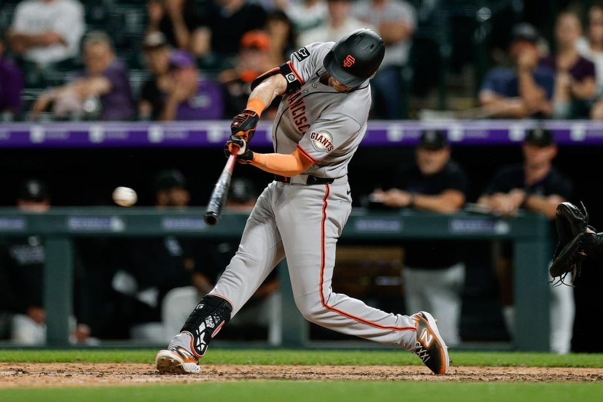 Jun 10, 2025; Denver, Colorado, USA; San Francisco Giants right fielder Mike Yastrzemski (5) hits an RBI single in the ninth inning against the Colorado Rockies at Coors Field. Mandatory Credit: Isaiah J. Downing-Imagn Images