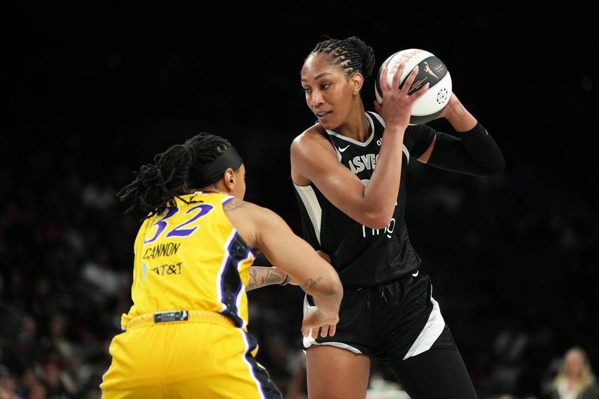 Jun 11, 2025; Las Vegas, Nevada, USA; Las Vegas Aces center A'ja Wilson (22) controls the ball against Los Angeles Sparks forward Emma Cannon (32) during the first half of a WNBA basketball game at Michelob Ultra Arena. Mandatory Credit: Lucas Peltier-Imagn Images
