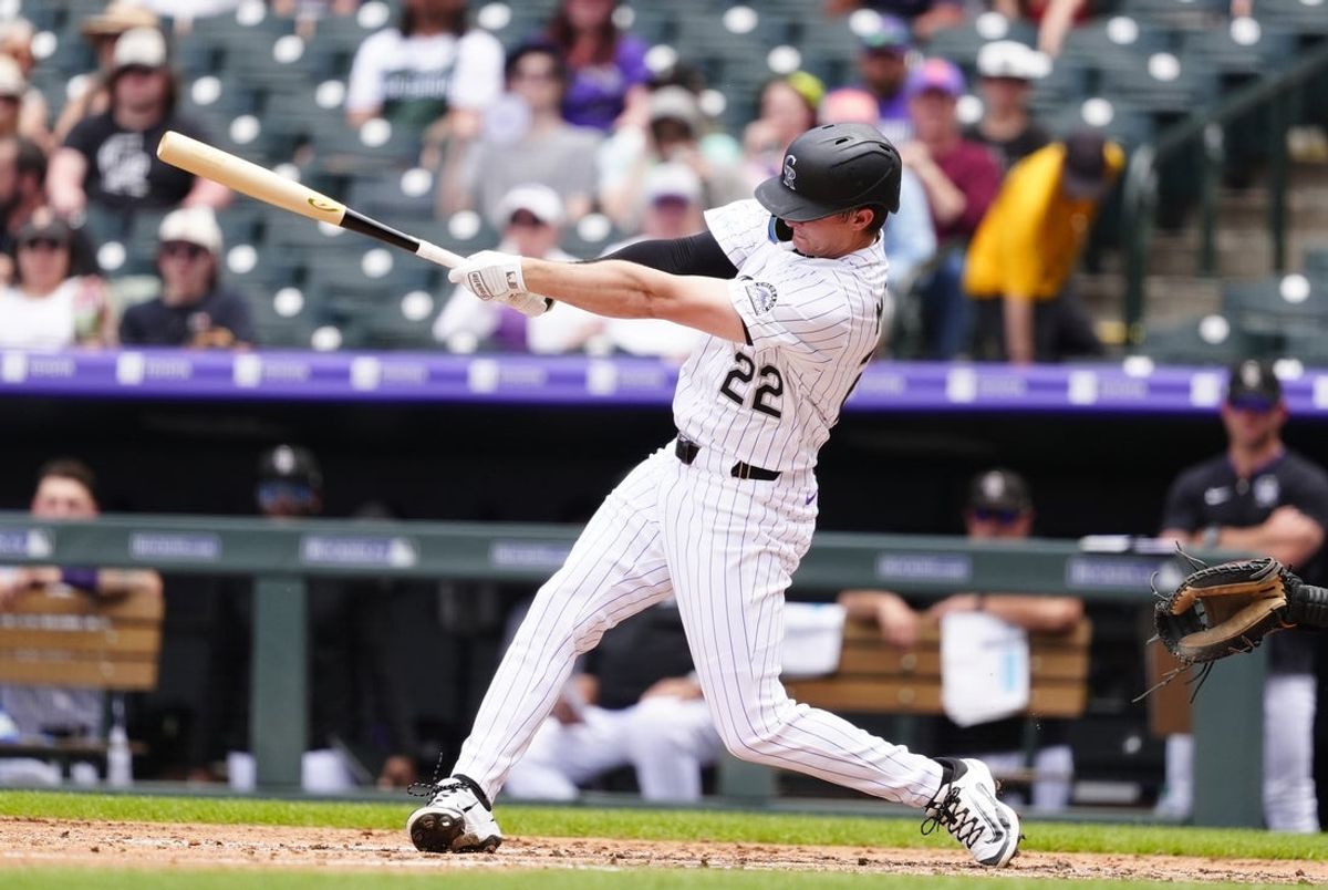 Jun 12, 2025; Denver, Colorado, USA; Colorado Rockies right fielder Mickey Moniak (22) hits a solo home run in the sixth inning against the Colorado Rockies at Coors Field. Mandatory Credit: Ron Chenoy-Imagn Images