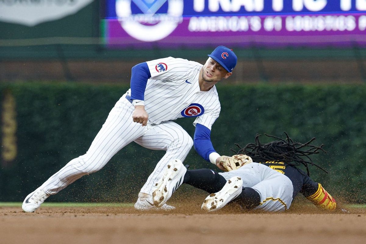 Jun 12, 2025; Chicago, Illinois, USA; Pittsburgh Pirates center fielder Oneil Cruz (15) is caught stealing second by Chicago Cubs second baseman Nico Hoerner (2) during the third inning at Wrigley Field. Mandatory Credit: Kamil Krzaczynski-Imagn Images