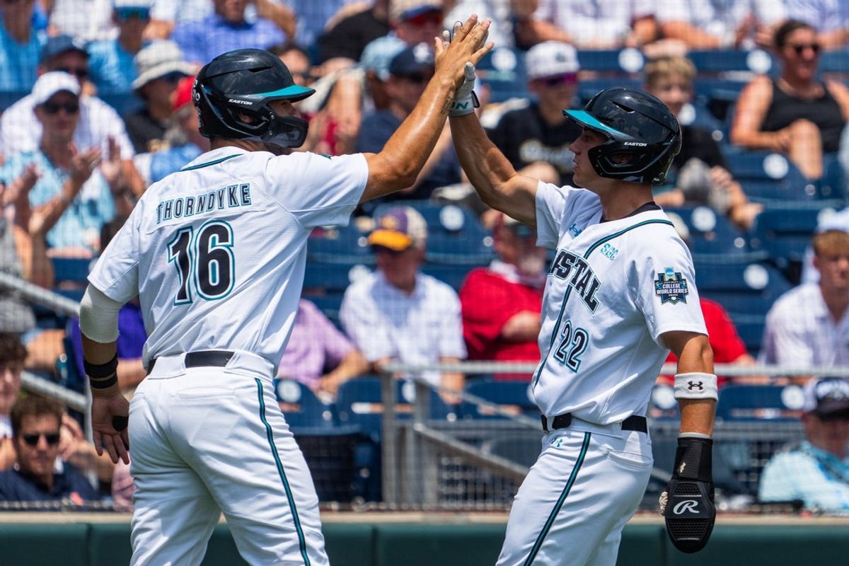 Jun 13, 2025; Omaha, Neb, USA;Coastal Carolina Chanticleers first baseman Colby Thorndyke (16) and Coastal Carolina Chanticleers right fielder Blagen Pado (22) celebrate after scoring against the Arizona Wildcats at Charles Schwab Field. Mandatory Credit: Dylan Widger-Imagn Images