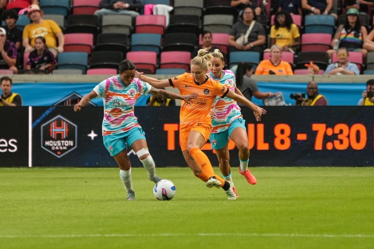 Jun 13, 2025; Houston, Texas, USA; Houston Dash defender Natalie Jacobs (4) and San Diego Wave FC midfielder Gia Corley (11) going for the ball at Shell Energy Stadium. Mandatory Credit: Sean Thomas-Imagn Images
