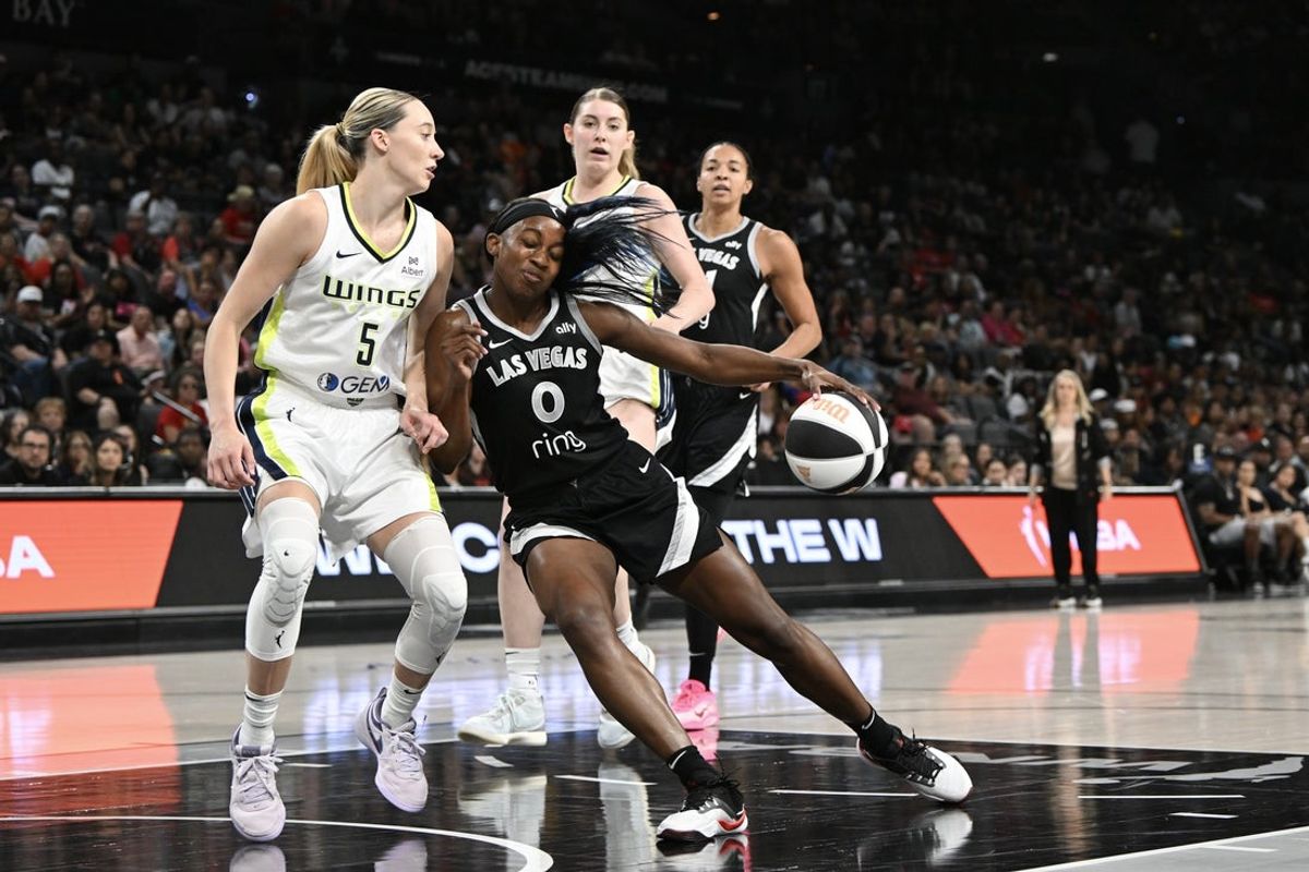 Jun 13, 2025; Las Vegas, Nevada, USA; Las Vegas Aces guard Jackie Young (0) collides with Dallas Wings guard Paige Bueckers (5) in the second quarter of their game at Michelob Ultra Arena. Mandatory Credit: Candice Ward-Imagn Images