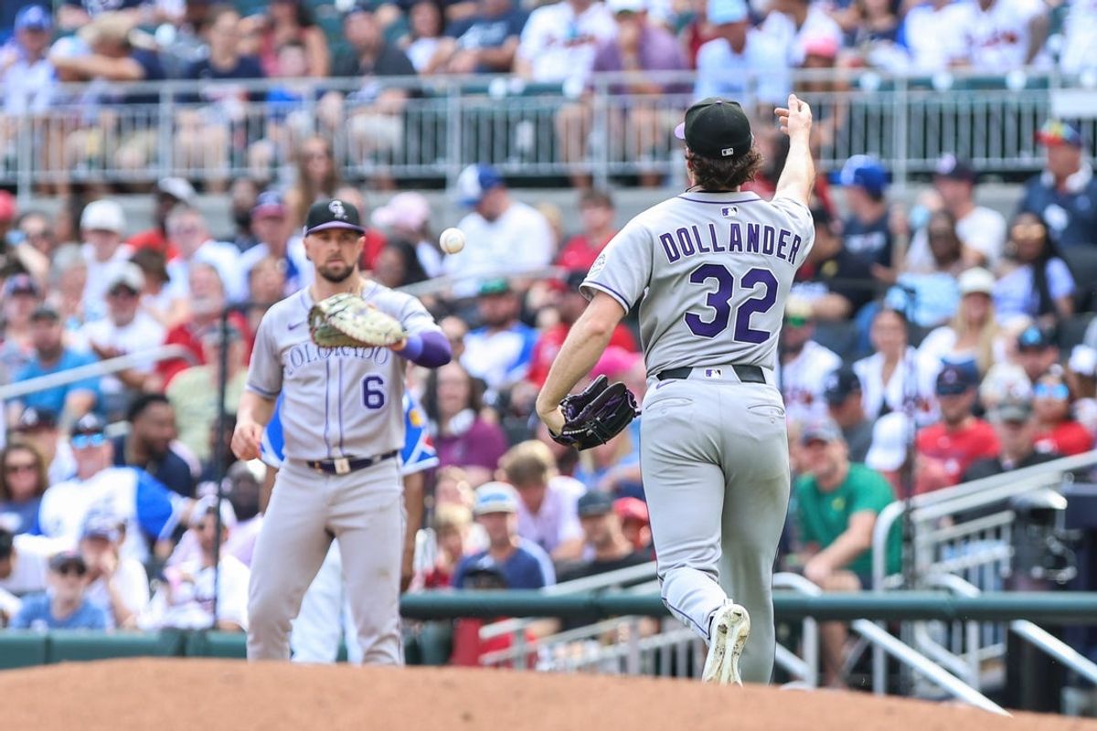 Jun 14, 2025; Cumberland, Georgia, USA; Colorado Rockies pitcher Chase Dollander (32) tosses the ball to second base Kyle Farmer (6) for an out against the Atlanta Braves during the fifth inning at Truist Park. Mandatory Credit: Jordan Godfree-Imagn Images