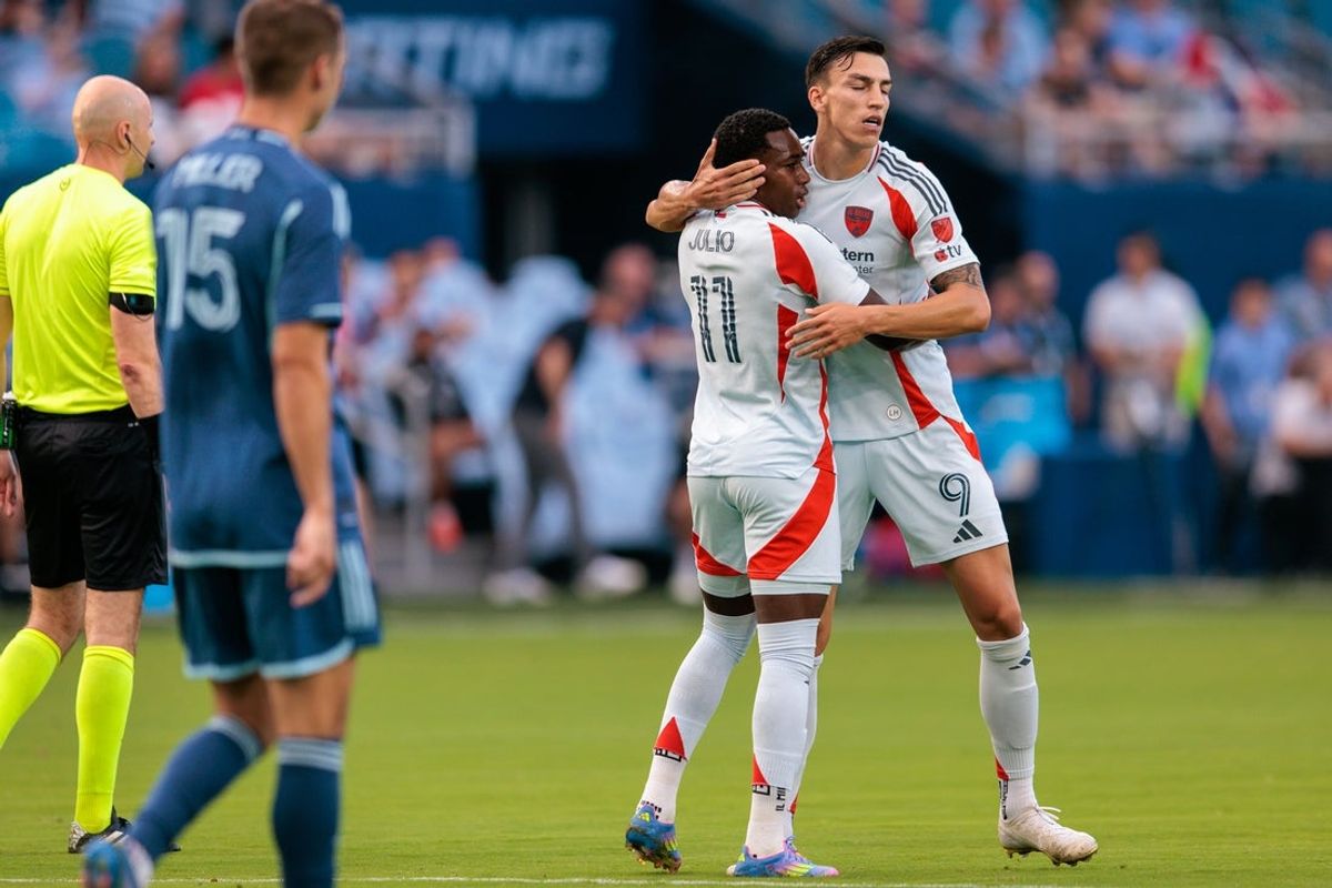 Jun 14, 2025; Kansas City, Kansas, USA; FC Dallas midfielder Anderson Julio (11) hugs forward Petar Musa (9) after scoring a goal during the first half against the Sporting Kansas City at Children's Mercy Park. Mandatory Credit: William Purnell-Imagn Images