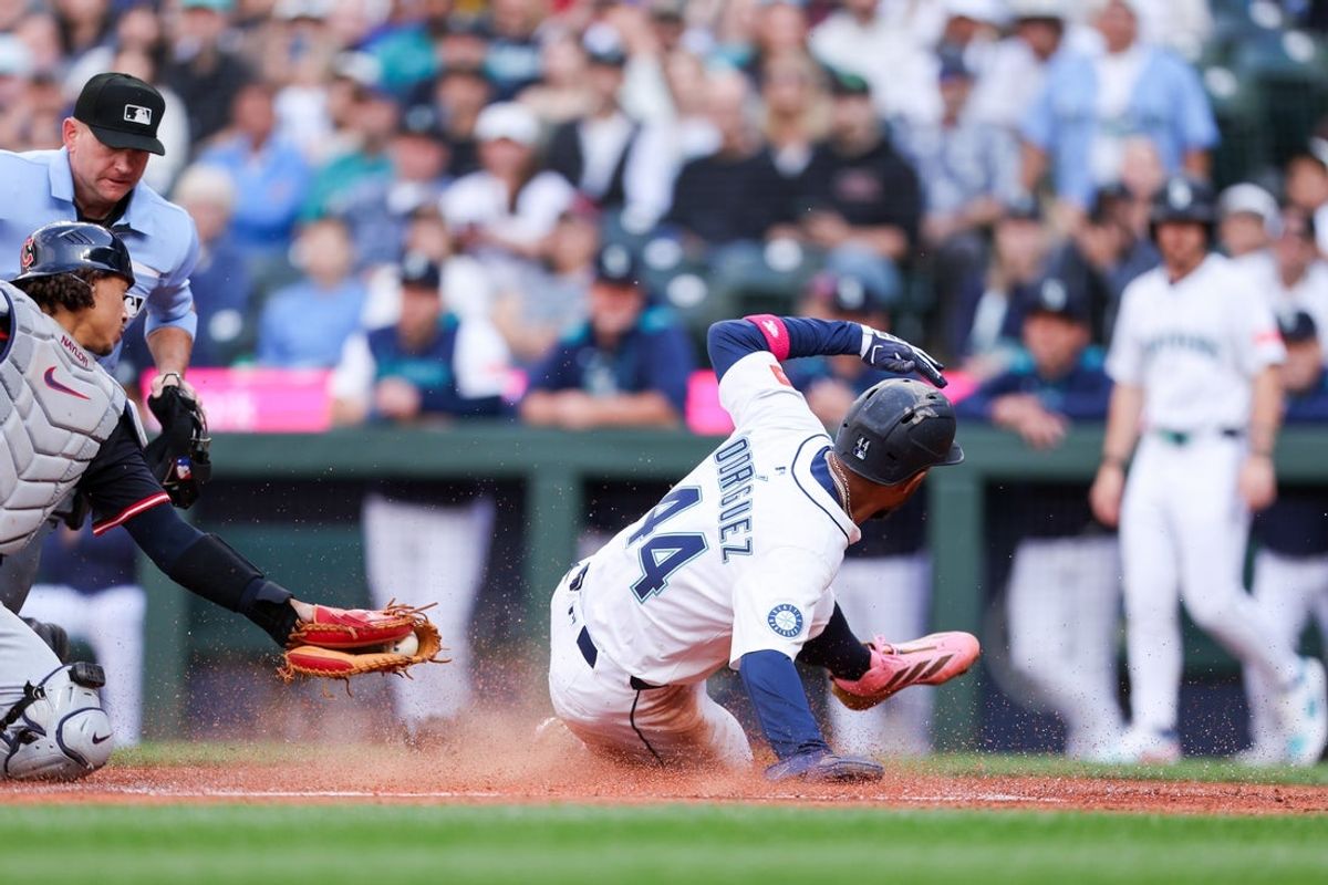 Jun 14, 2025; Seattle, Washington, USA; Seattle Mariners center fielder Julio Rodríguez (44) slides home after designated hitter Jorge Polcano (7) hits a sacrifice pop fly during the first inning against the Cleveland Guardians at T-Mobile Park. Mandatory Credit: Kevin Ng-Imagn Images