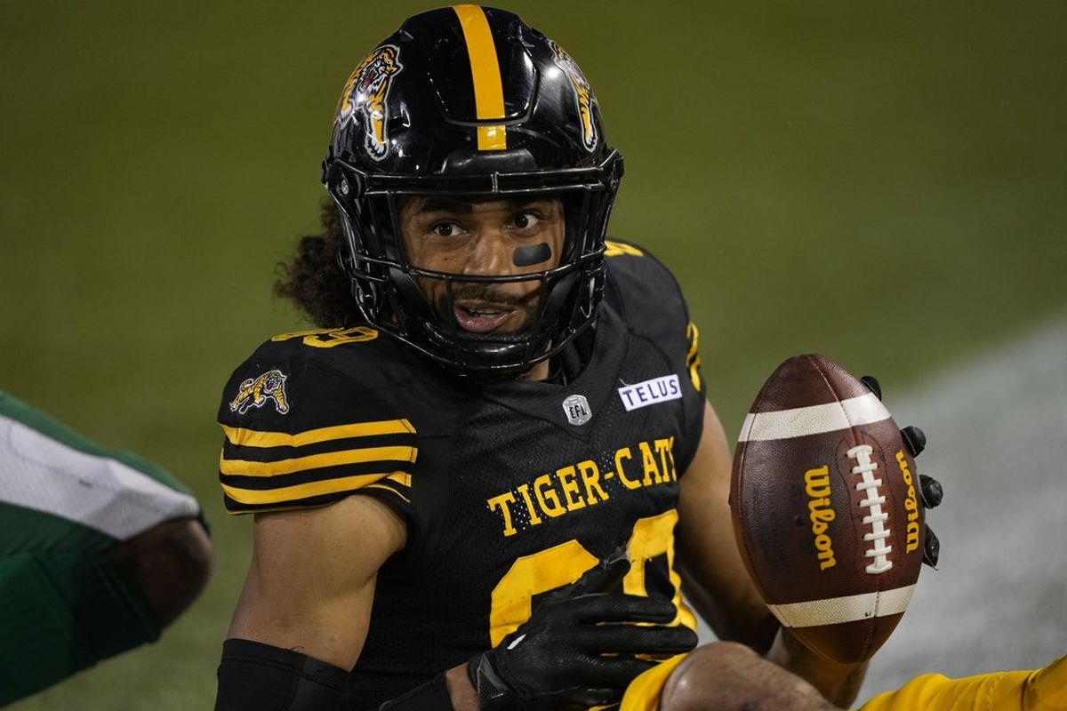 Jun 14, 2025; Hamilton, Ontario, Canada; Hamilton Tiger-Cats wide receiver Kenny Lawler (89) smiles after making a catch and being tackled at the goal line against the Saskatchewan Roughriders during the second half at Hamilton Stadium. Mandatory Credit: John E. Sokolowski-Imagn Images