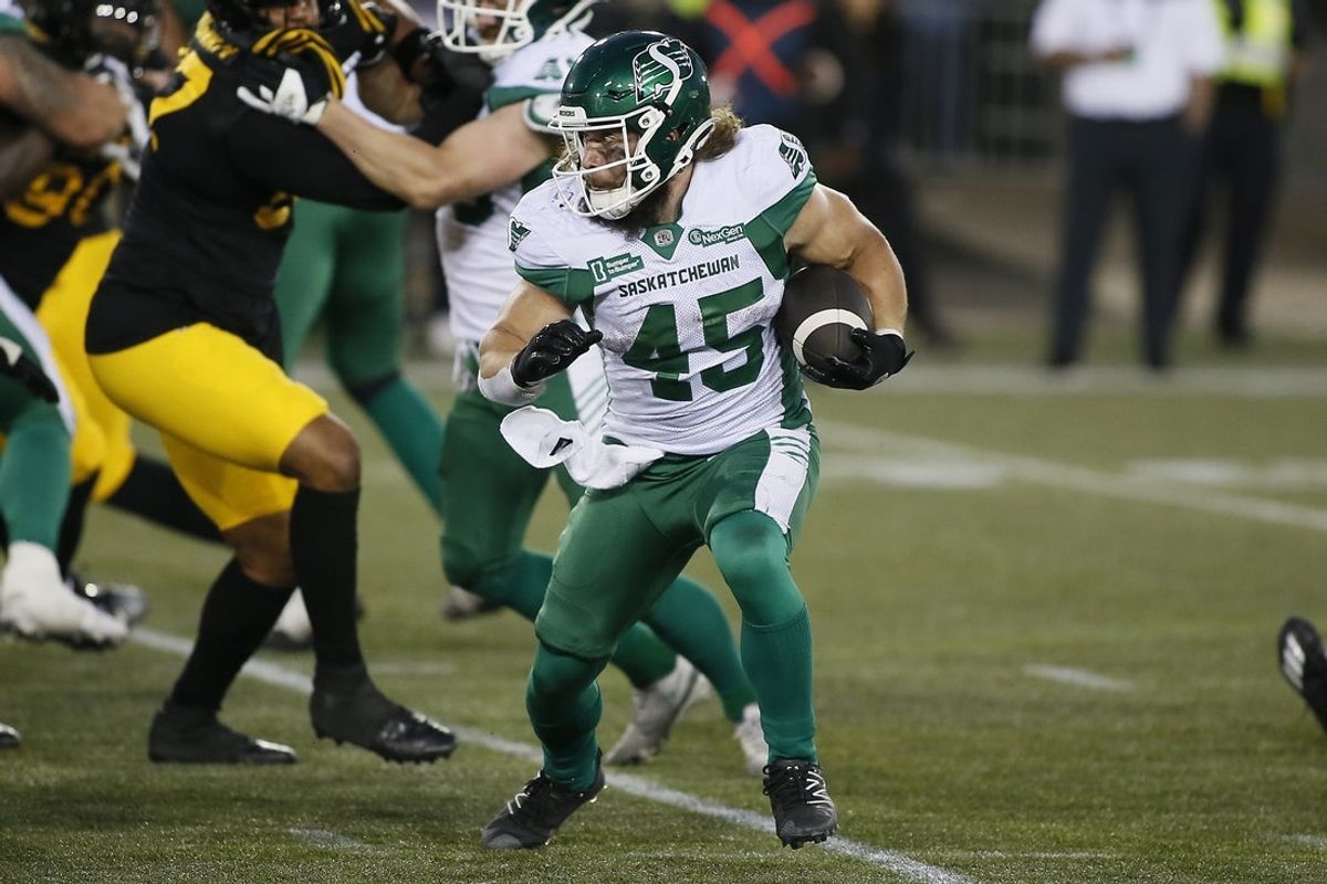 Jun 14, 2025; Hamilton, Ontario, Canada; Saskatchewan Roughriders running back A.J. Ouellette (45) runs with ball against the Hamilton Tiger-Cats during the second half at Hamilton Stadium. Mandatory Credit: John E. Sokolowski-Imagn Images