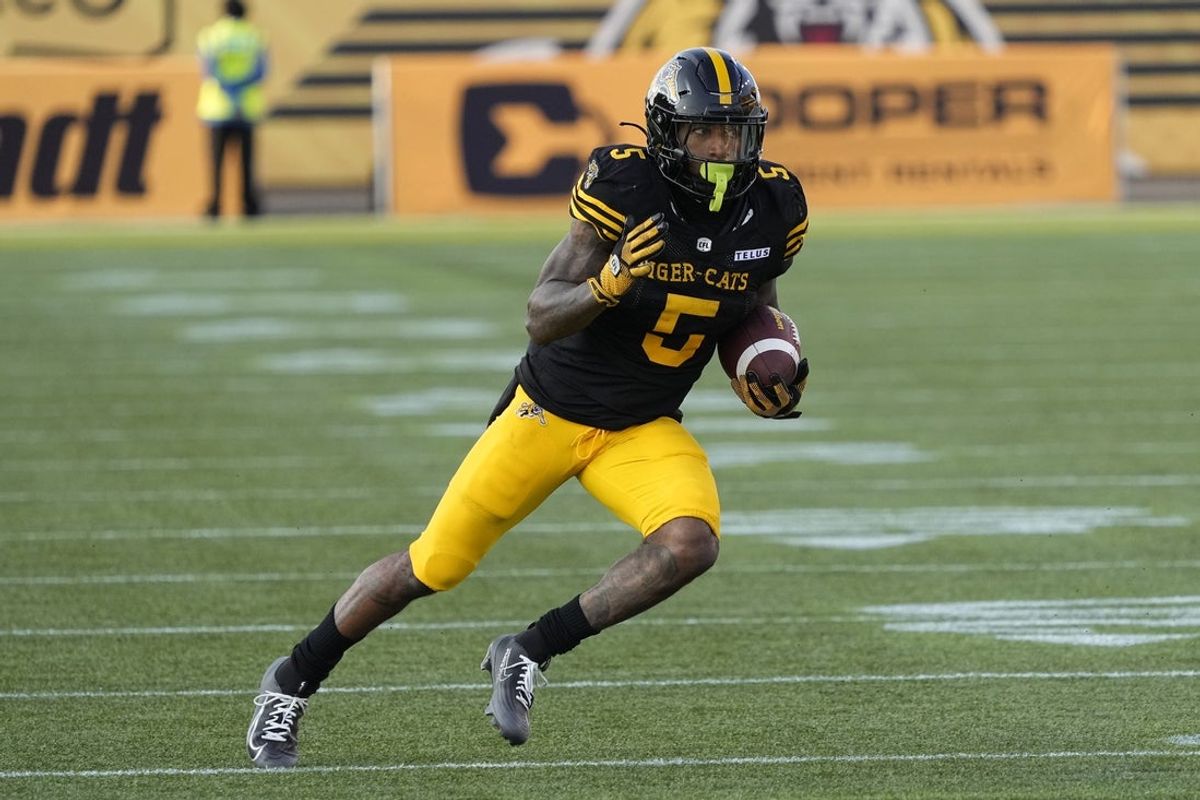 Jun 14, 2025; Hamilton, Ontario, Canada; Hamilton Tiger-Cats running back Greg Bell (5) runs with the ball after a pass reception against the Saskatchewan Roughriders during the first  half at Hamilton Stadium. Mandatory Credit: John E. Sokolowski-Imagn Images