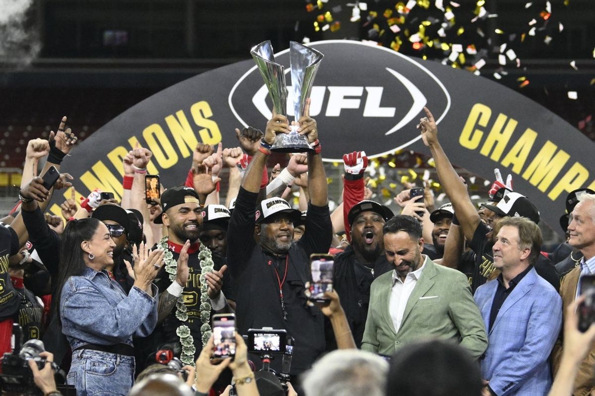 Jun 14, 2025; St. Louis, MO, USA;  DC Defenders head coach Shannon Harris raises the UFL Championship trophy after defeating the Michigan Panthers in the 2025 UFL Championship at The Dome at America’s Center. Mandatory Credit: Jeff Le-Imagn Images