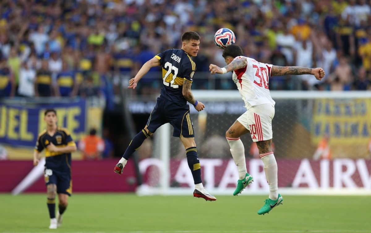 Jun 16, 2025; Miami Gardens, Florida, USA; CA Boca Juniors midfielder Kevin Zenon (22) and SL Benfica defender Nicolas Otamendi (30) battle for control of the ball during the second half in a group stage match of the 2025 FIFA Club World Cup at Hard Rock Stadium. Mandatory Credit: Nathan Ray Seebeck-Imagn Images