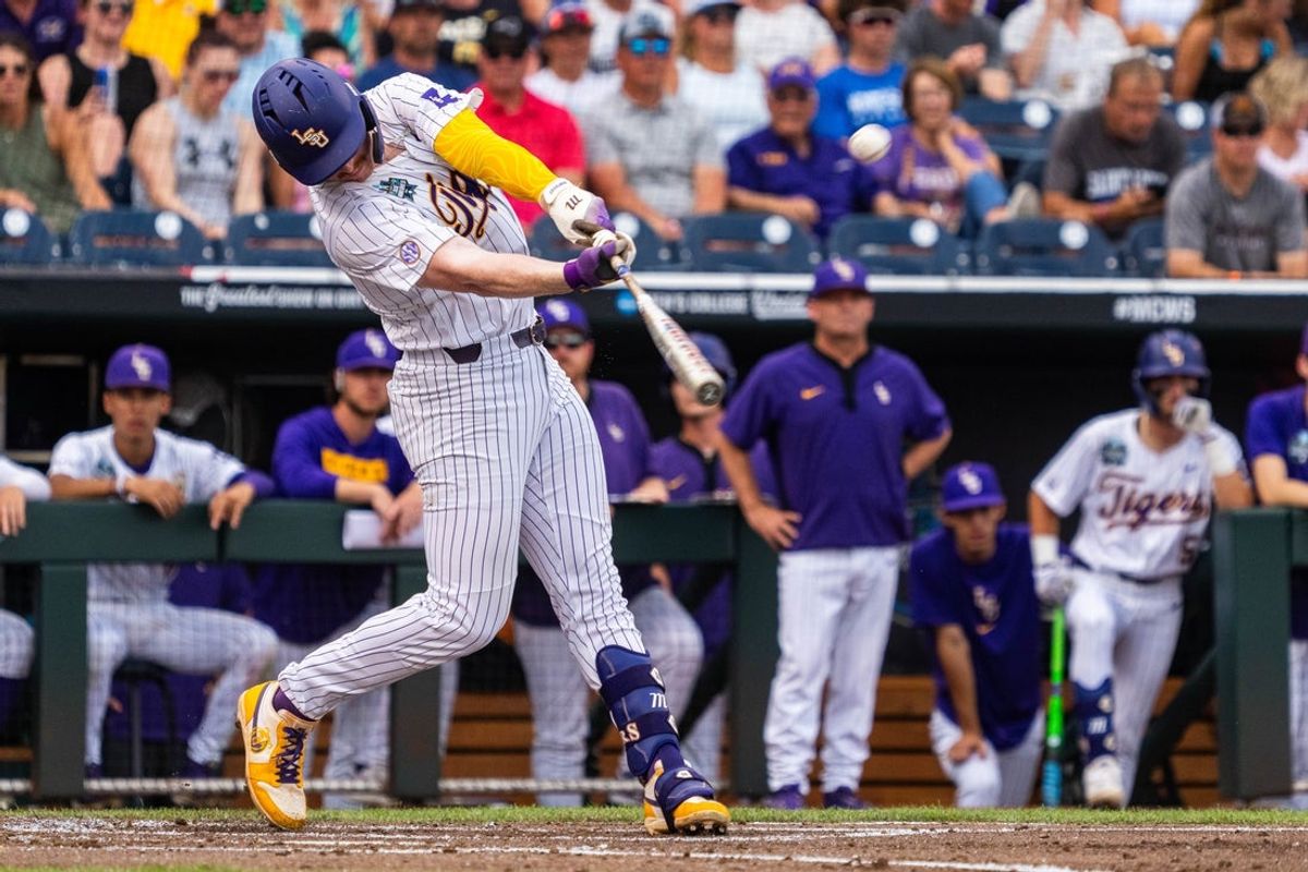 Jun 16, 2025; Omaha, Neb, USA; LSU Tigers first baseman Jared Jones (22) hits a three-run home run against the UCLA Bruins during the first inning at Charles Schwab Field. Mandatory Credit: Dylan Widger-Imagn Images