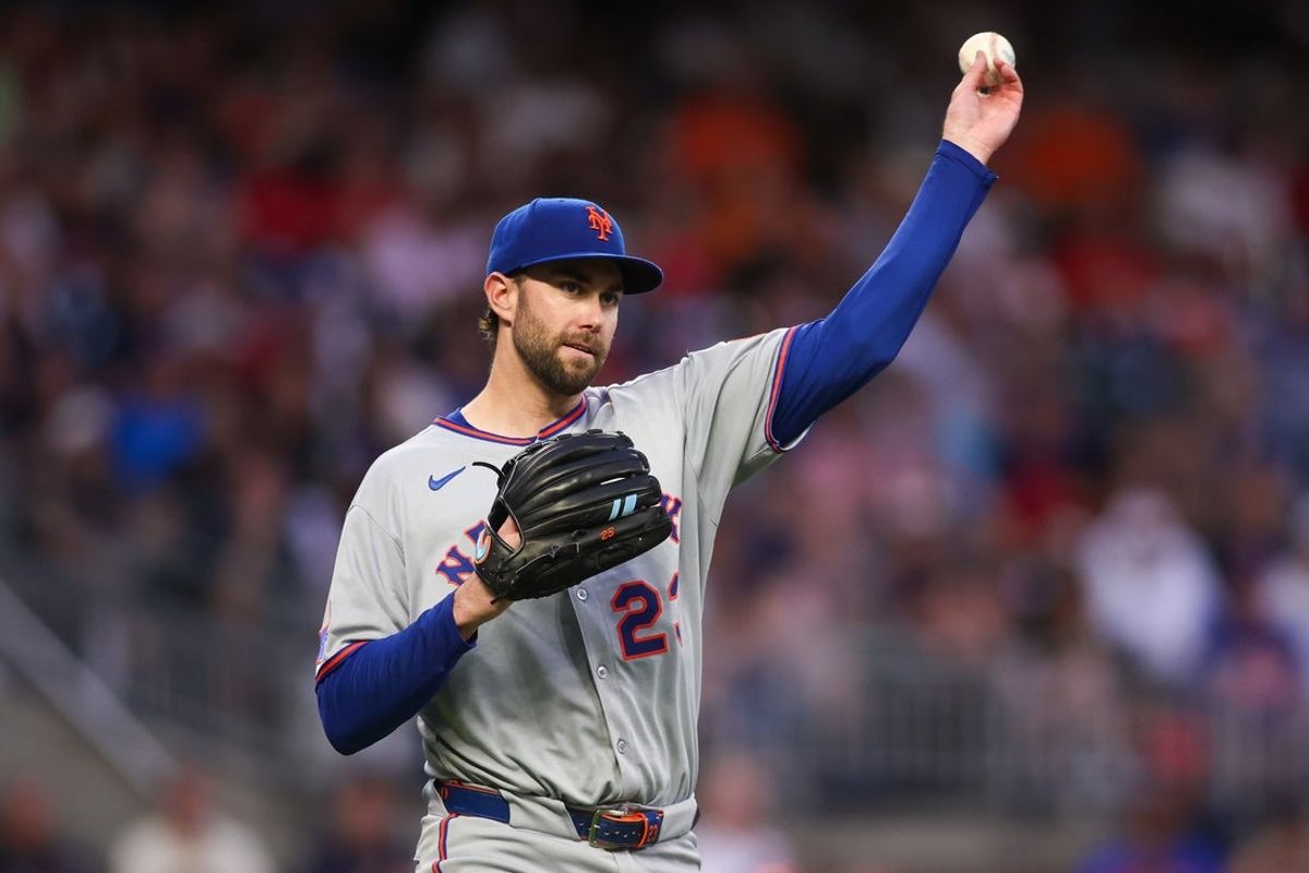 Jun 17, 2025; Atlanta, Georgia, USA; New York Mets starting pitcher David Peterson (23) throws a runner out at first against the Atlanta Braves in the second inning at Truist Park. Mandatory Credit: Brett Davis-Imagn Images