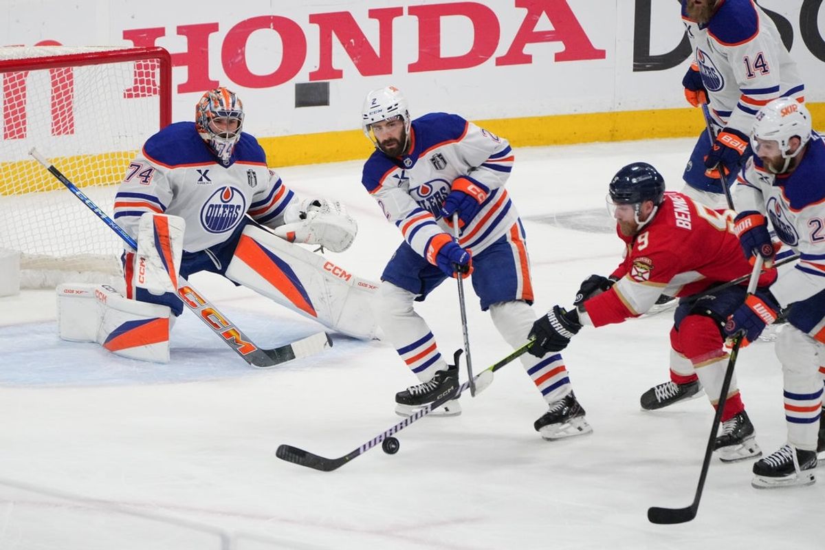 Jun 17, 2025; Sunrise, Florida, USA; Edmonton Oilers goaltender Stuart Skinner (74) watches as teammate defenseman Evan Bouchard (2) clears the puck away from Florida Panthers center Sam Bennett (9) during the first period in game six of the 2025 Stanley Cup Final at Amerant Bank Arena. Mandatory Credit: Jim Rassol-Imagn Images