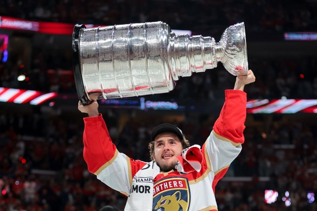 Jun 17, 2025; Sunrise, Florida, USA; Florida Panthers right wing Mackie Samoskevich (25) hoists the Stanley Cup after winning game six of the 2025 Stanley Cup Final against the Edmonton Oilers at Amerant Bank Arena. Mandatory Credit: Sam Navarro-Imagn Images