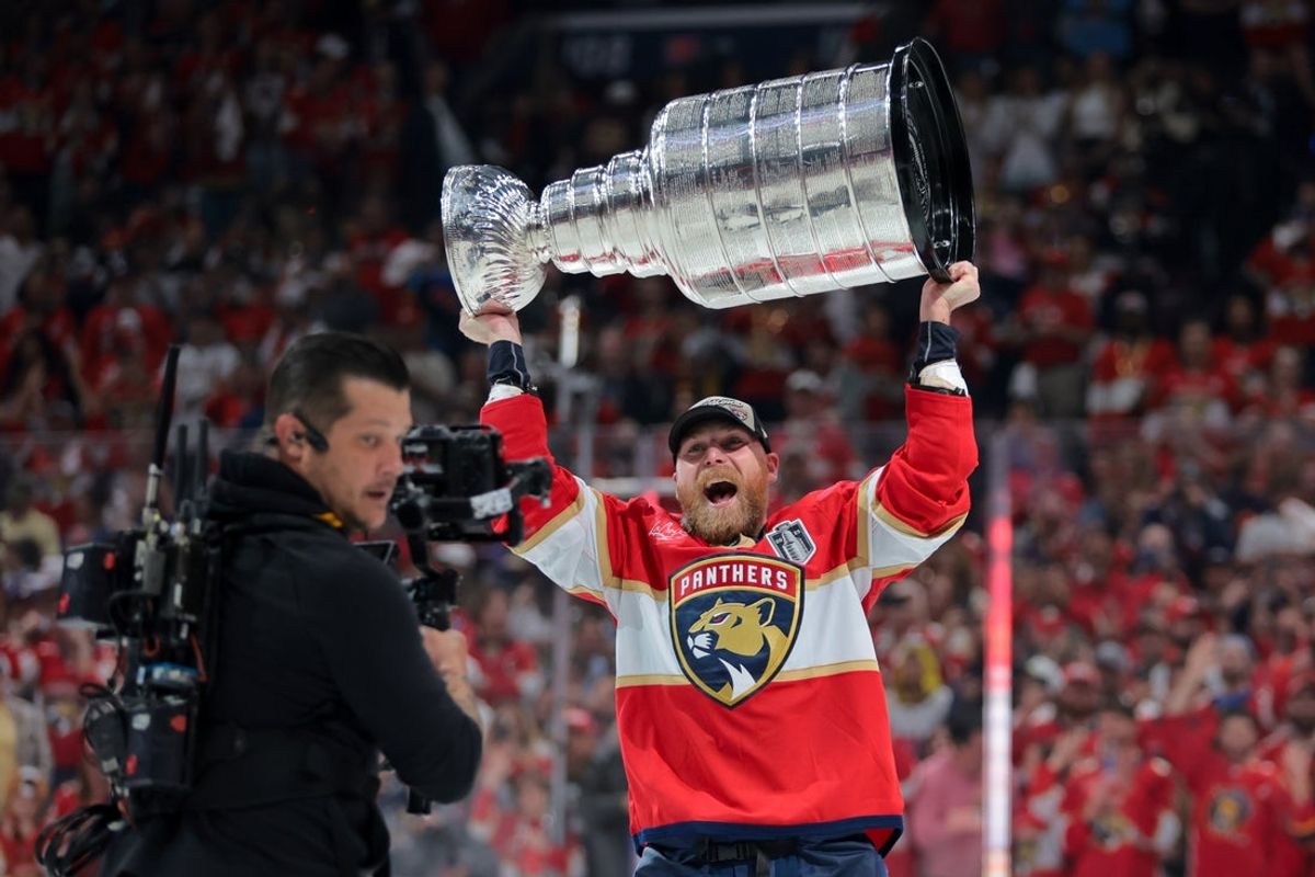 Jun 17, 2025; Sunrise, Florida, USA; Florida Panthers center Sam Bennett (9) hoists the Stanley Cup after winning game six of the 2025 Stanley Cup Final against the Edmonton Oilers at Amerant Bank Arena. Mandatory Credit: Sam Navarro-Imagn Images