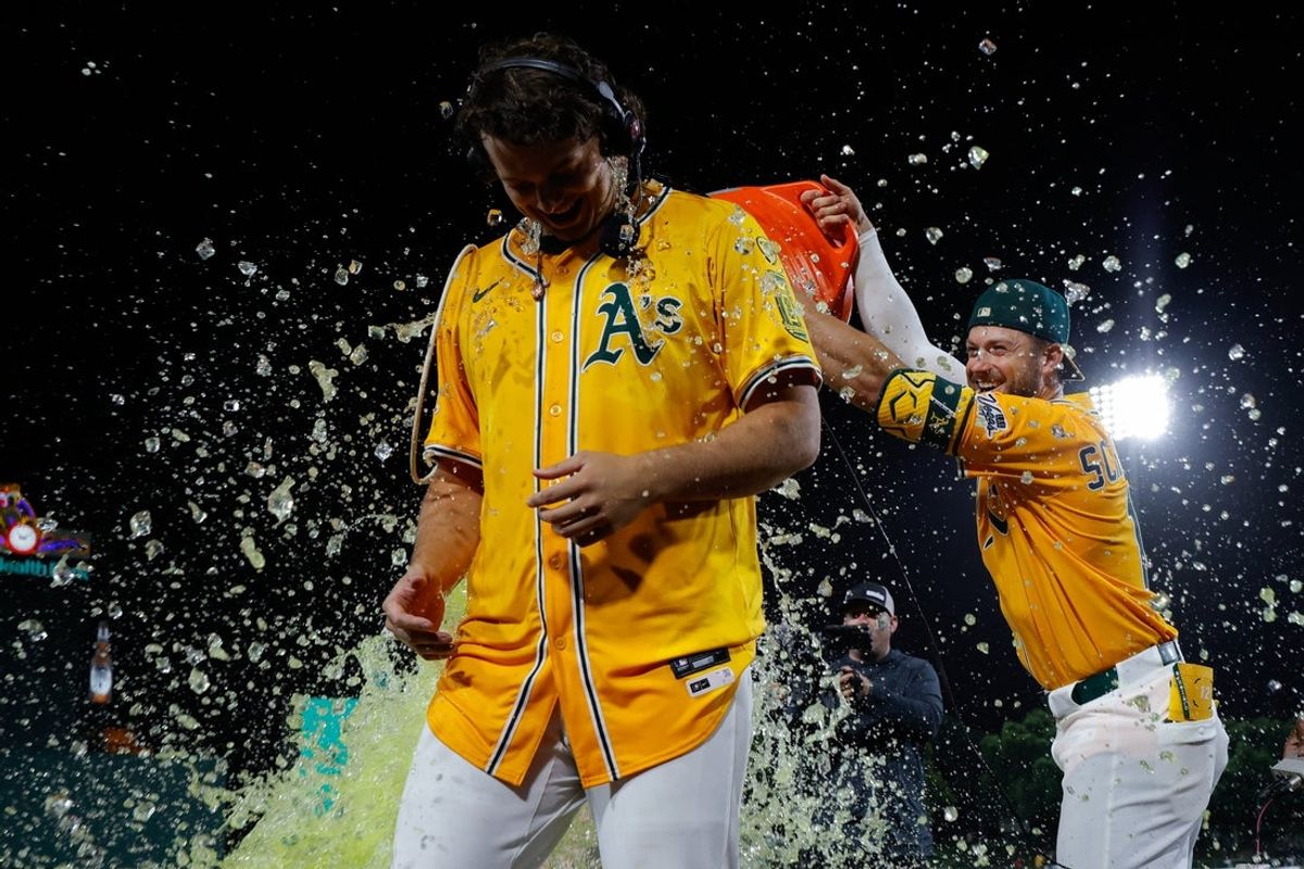Jun 19, 2025; West Sacramento, California, USA; Athletics first baseman Nick Kurtz (16) gets a gatorade splash by third base Max Schuemann (12) and right fielder Lawrence Butler (4) after hitting a walk-off two run home run during the tenth inning against the Houston Astros at Sutter Health Park. Mandatory Credit: Sergio Estrada-Imagn Images