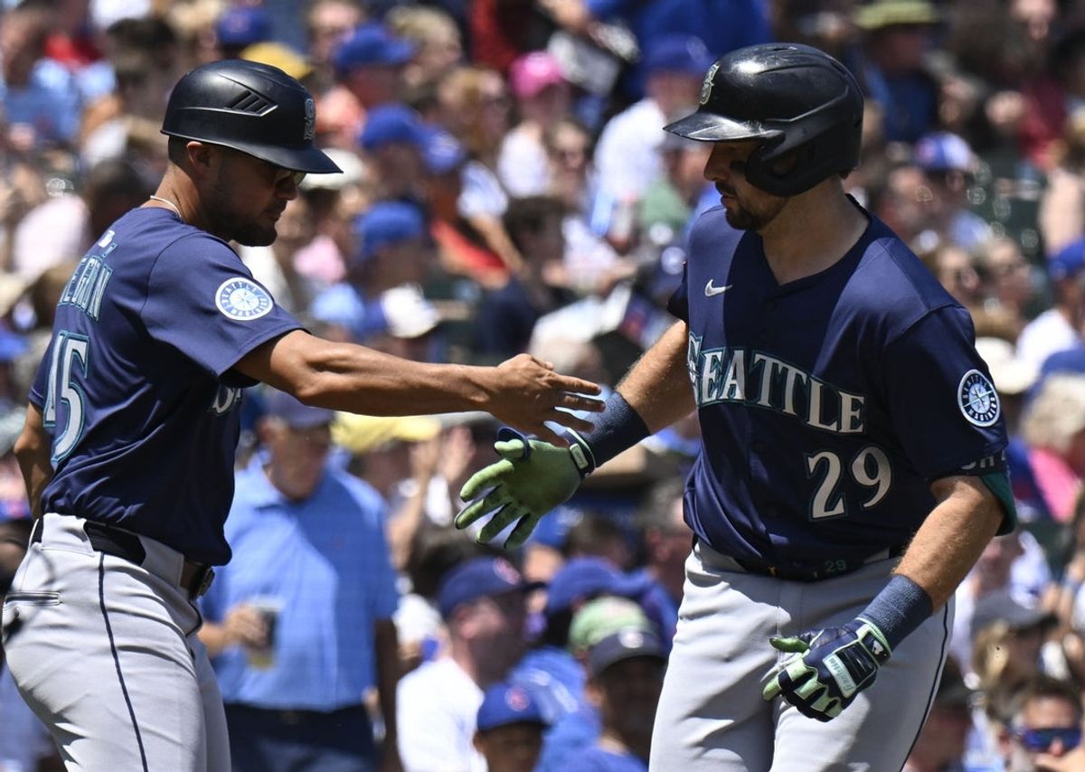 Jun 20, 2025; Chicago, Illinois, USA;  Seattle Mariners catcher Cal Raleigh (29) high fives Seattle Mariners third base coach Kristopher Negron (45)  after he hits a home run against the Chicago Cubs during the first inning at Wrigley Field. Mandatory Credit: Matt Marton-Imagn Images