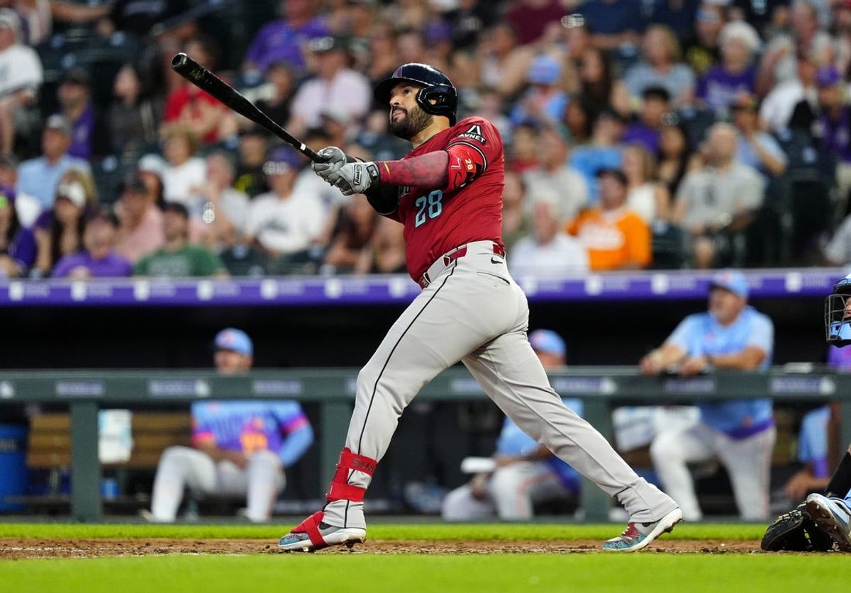 Jun 20, 2025; Denver, Colorado, USA; Arizona Diamondbacks third baseman Eugenio Suarez (28) hits a two run home run in the sixth inning against the Colorado Rockies at Coors Field. Mandatory Credit: Ron Chenoy-Imagn Images