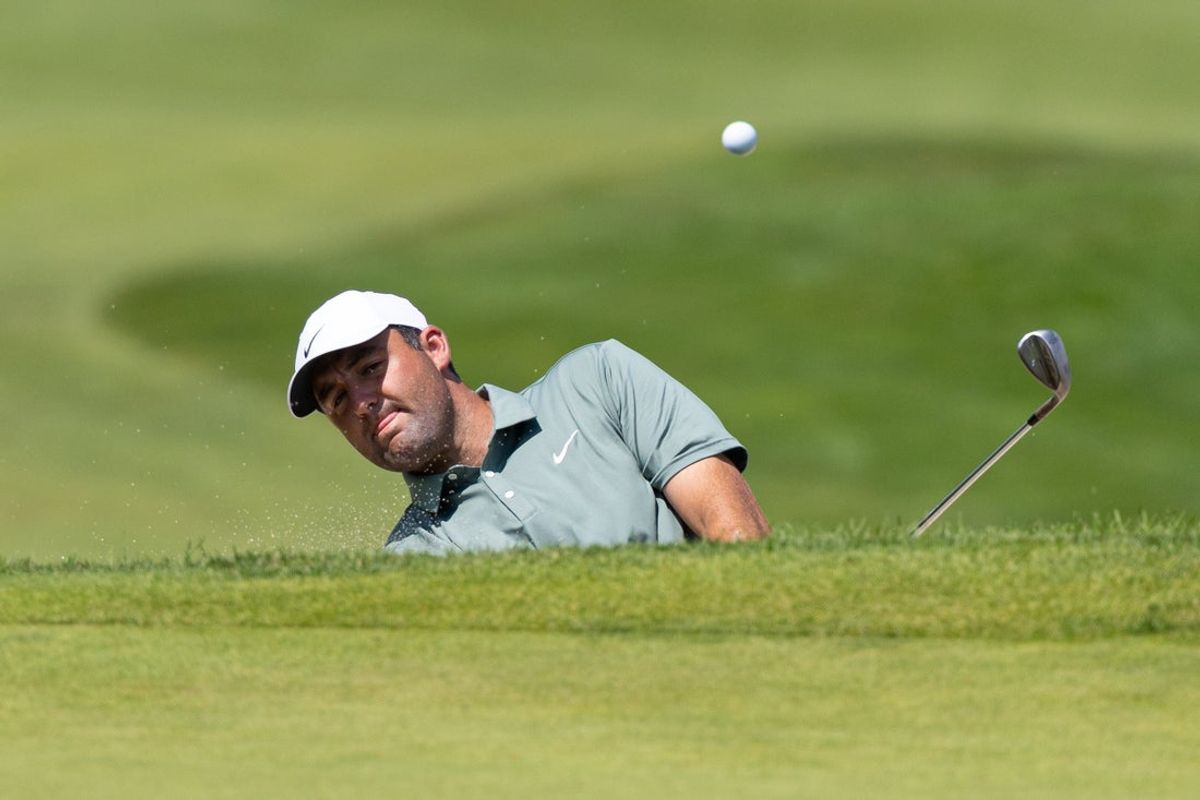 Jun 21, 2025; Cromwell, Connecticut, USA; Scottie Scheffler plays a shot from a bunker on the first hole during the third round of the Travelers Championship golf tournament. Mandatory Credit: Bill Streicher-Imagn Images