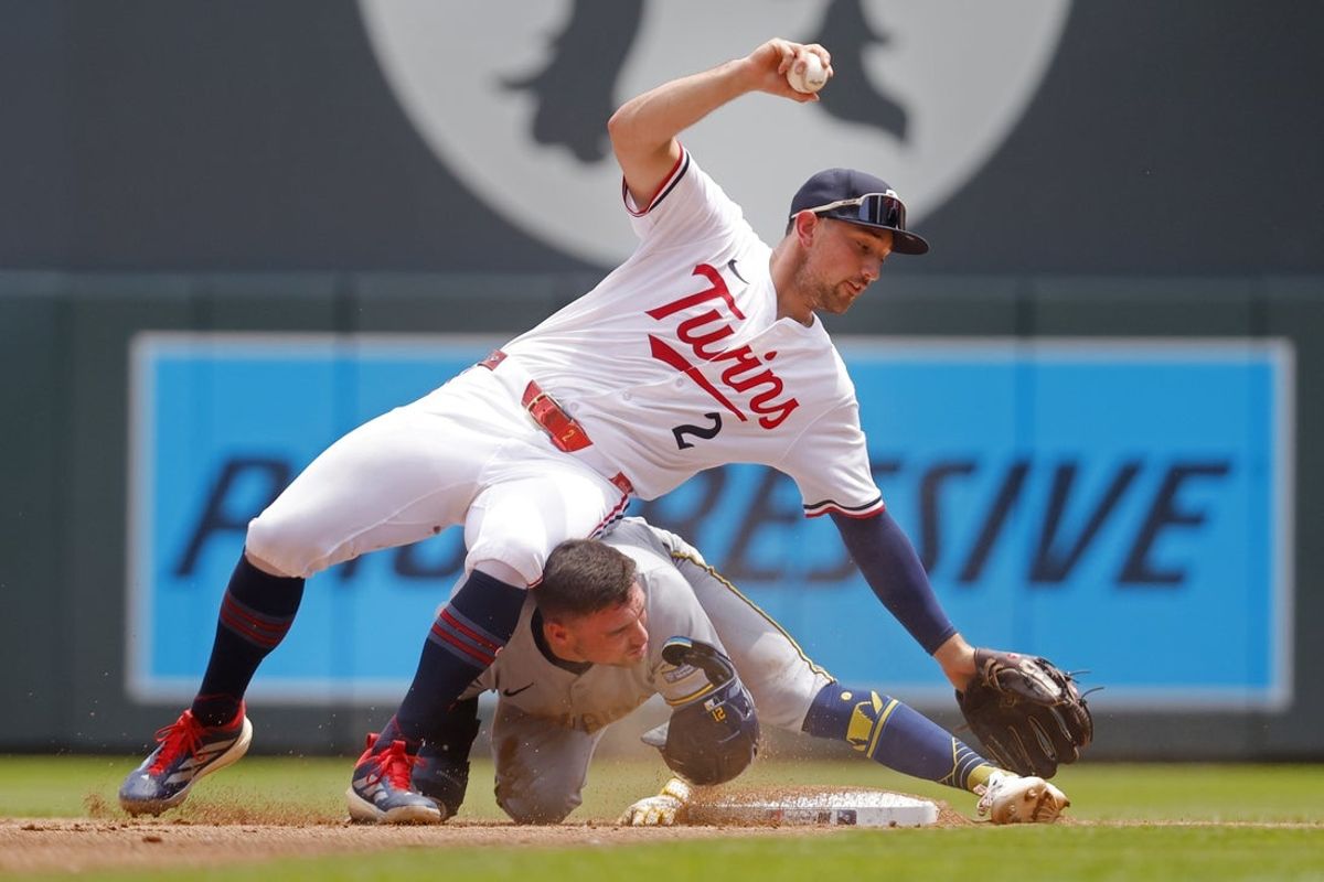 Jun 21, 2025; Minneapolis, Minnesota, USA; Milwaukee Brewers third baseman Caleb Durbin (21) slides into second base and Minnesota Twins shortstop Carlos Correa (4) preventing the out or a turn at a double play in the second inning at Target Field. Mandatory Credit: Bruce Kluckhohn-Imagn Images