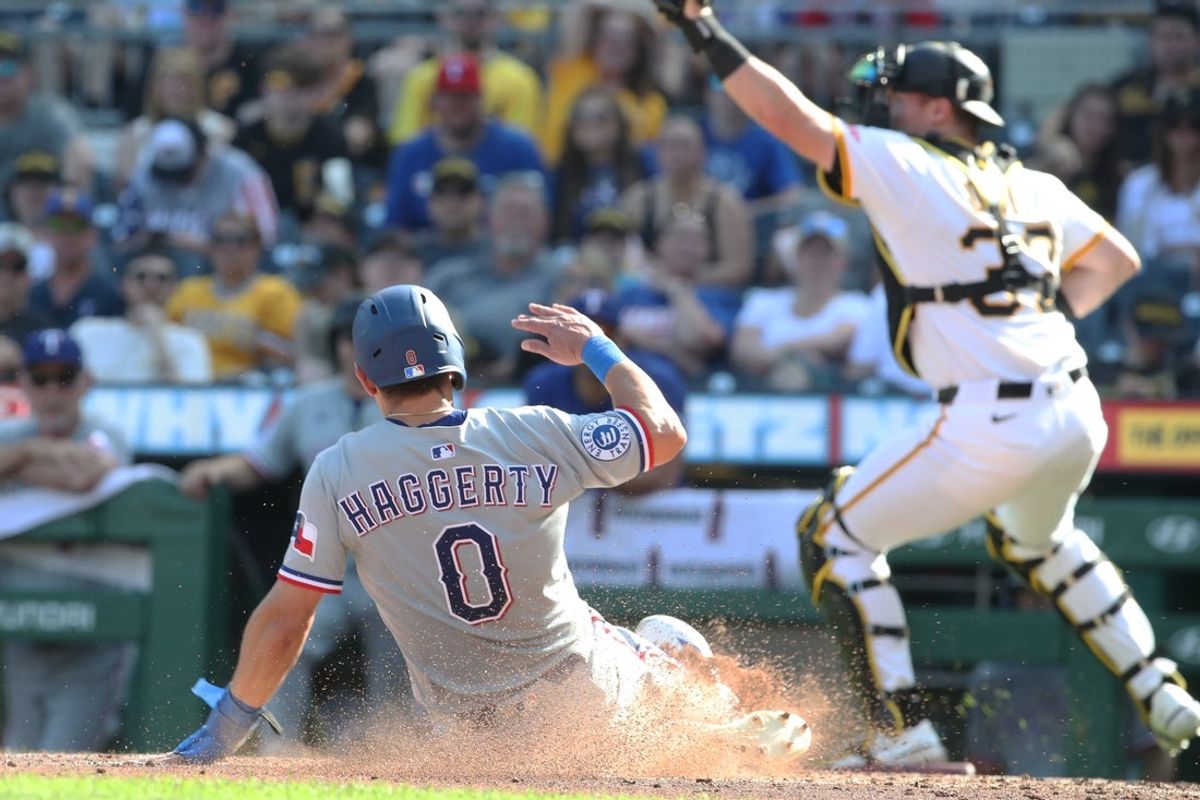 Jun 21, 2025; Pittsburgh, Pennsylvania, USA;  Texas Rangers left fielder Sam Haggerty (0) slides home to score a run as Pittsburgh Pirates catcher Henry Davis (32) takes an errant throw during the sixth inning  at PNC Park. Mandatory Credit: Charles LeClaire-Imagn Images