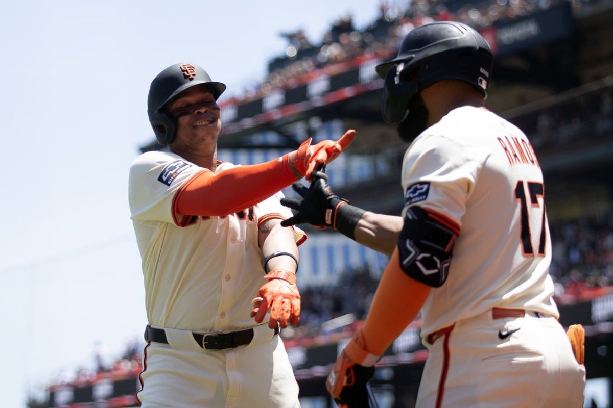 Jun 21, 2025; San Francisco, California, USA; San Francisco Giants designated hitter Rafael Devers (16) gets a congratulatory handshake from teammate Heliot Ramos (17) after hitting a two-run home run against the Boston Red Sox during the third inning at Oracle Park. Mandatory Credit: D. Ross Cameron-Imagn Images